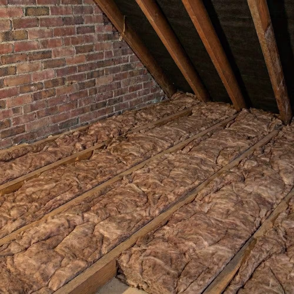 Glass-wool insulation rolls laid neatly between timber ceiling joists